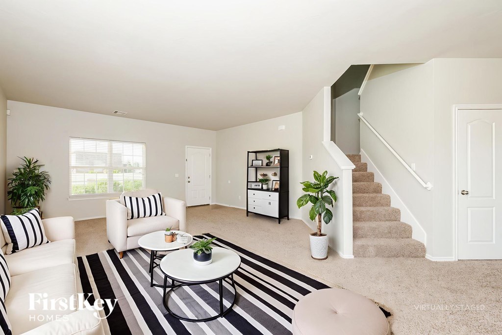A living room with a striped rug and a white couch.