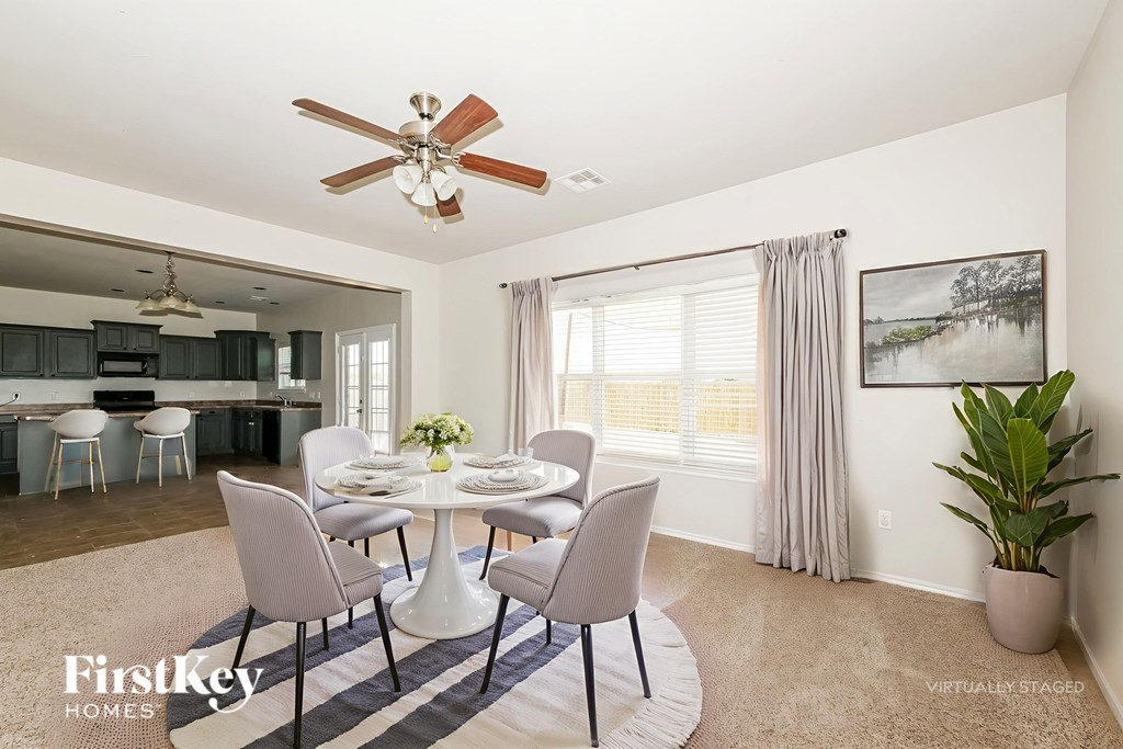 A dining room with a round table and chairs.