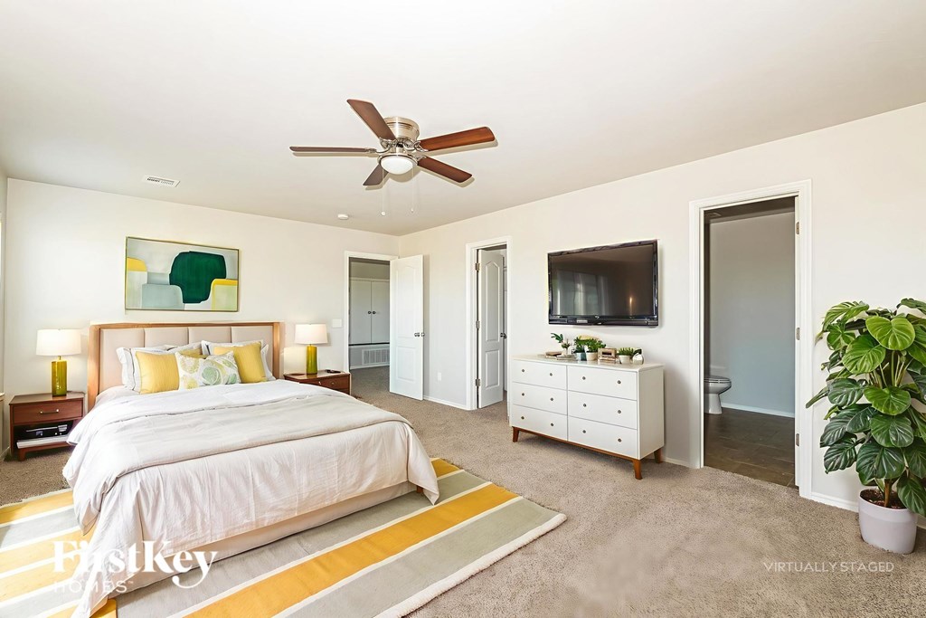 A bedroom with a large bed and a ceiling fan.