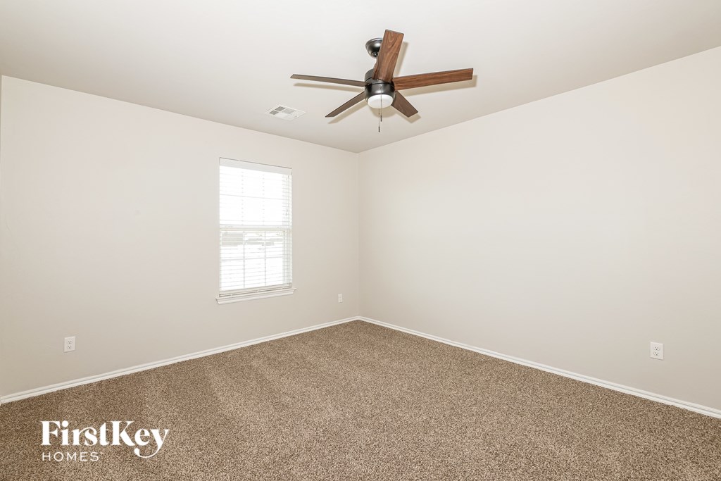 A room with a fan and a window.