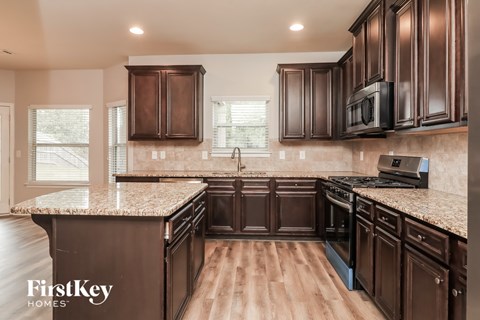 A kitchen with brown cabinets and a granite countertop.