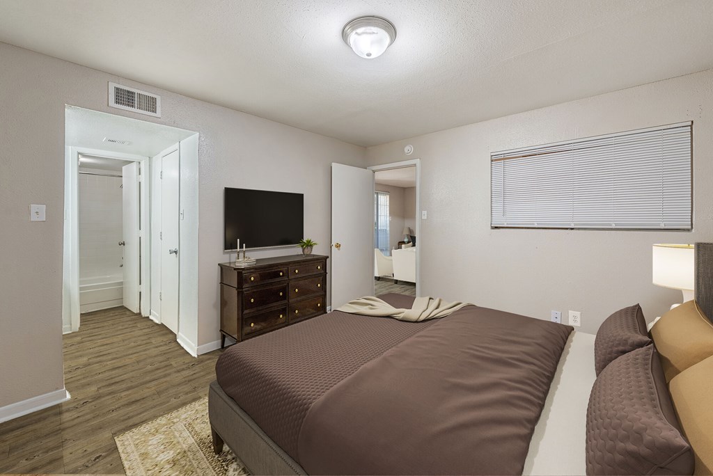 A bedroom with a bed, dresser, and mirror.