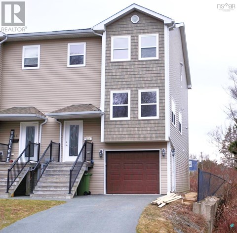 A two-story house with a garage and a driveway.
