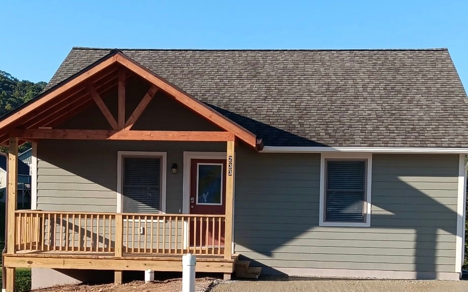 A house with a grey siding and a brown roof.