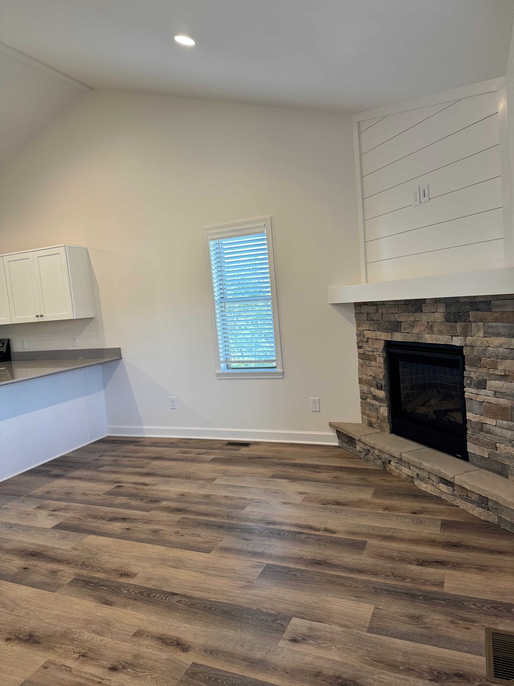 A room with a fireplace and wooden flooring.
