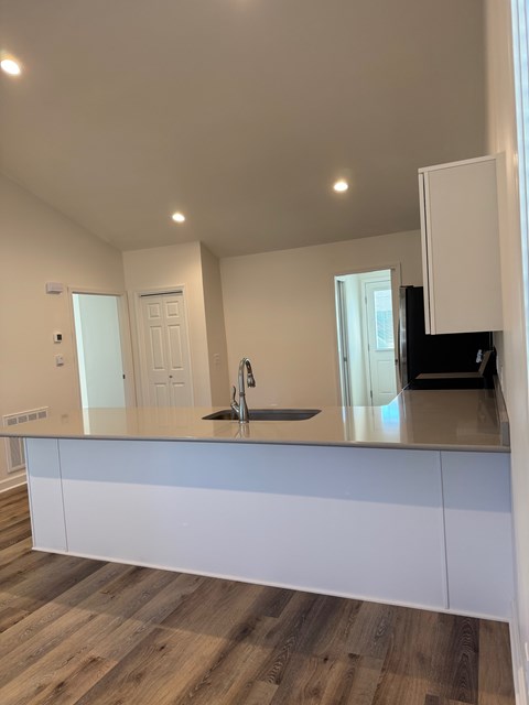 A kitchen with white cabinets and a dark countertop.