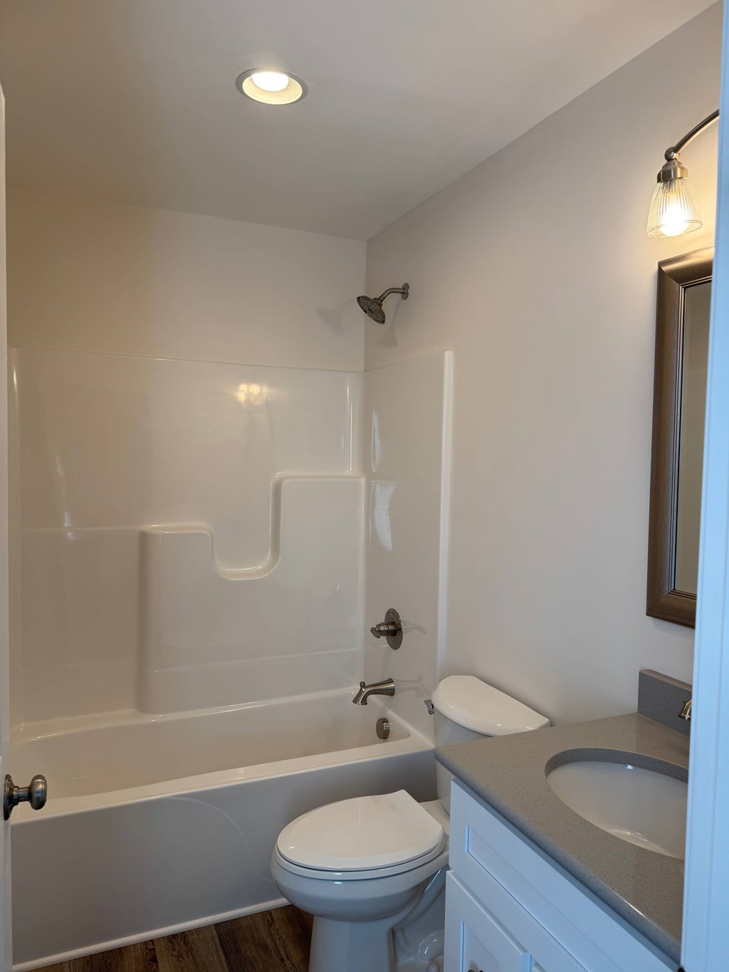 A white toilet sits next to a bathtub in a bathroom.
