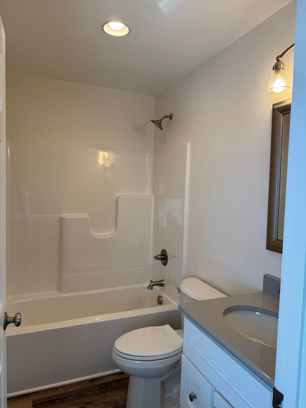 A white toilet sits next to a bathtub in a bathroom.