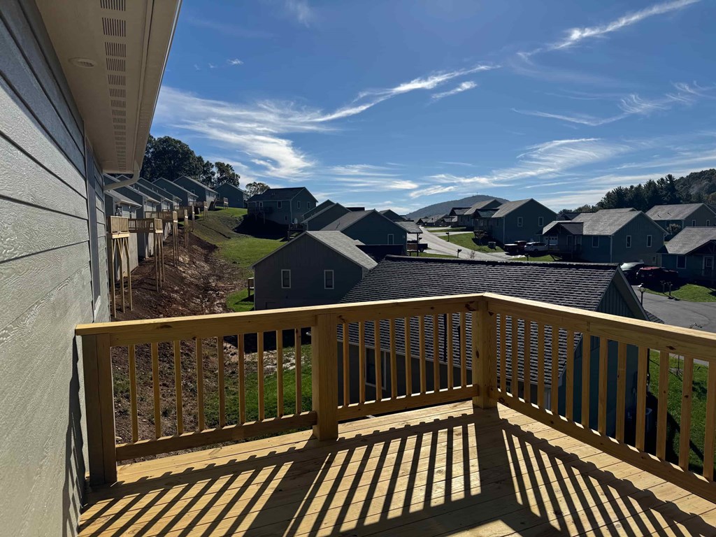 A wooden balcony overlooks a residential area.