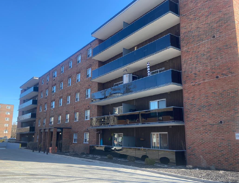 A large red brick building with balconies on the second floor.