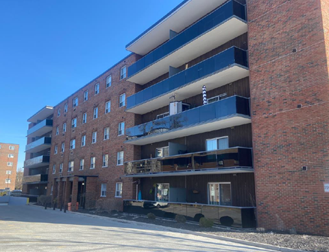 A large red brick building with balconies on the second floor.