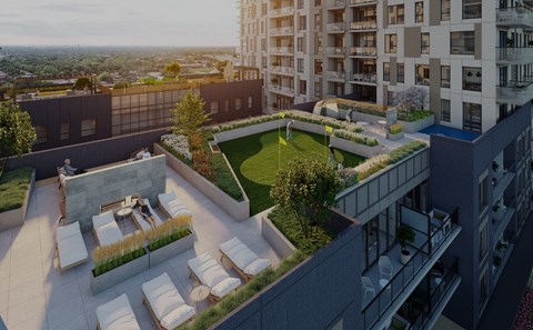 A rooftop patio with white chairs and a fire pit.