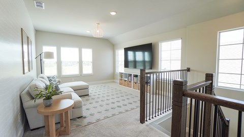 A living room with a couch, a table, and a plant.