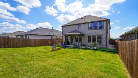 A house with a grey roof and a wooden fence.