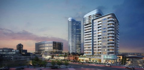 A modern building with a curved glass facade stands tall among other buildings.