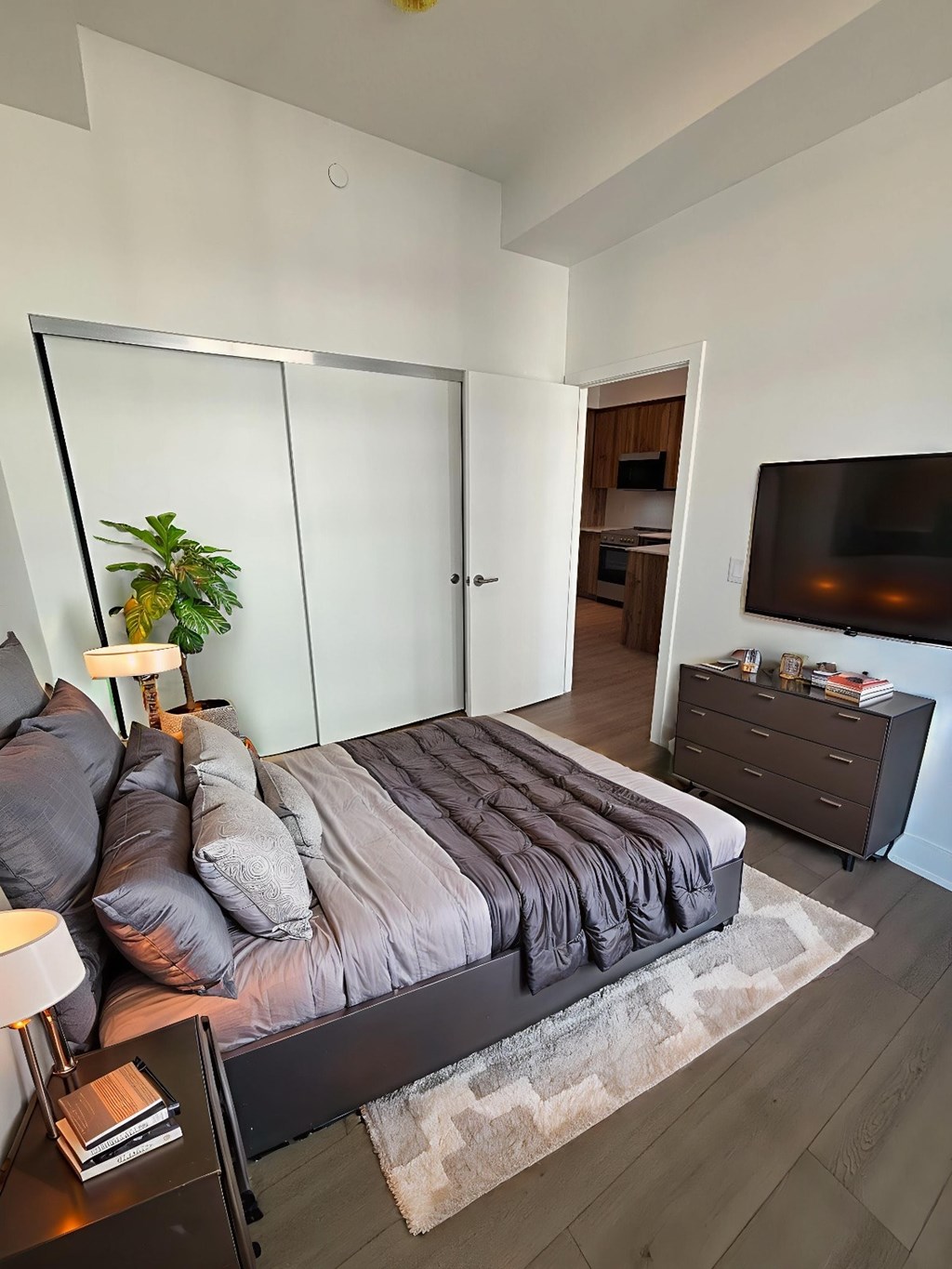 A bedroom with a bed, nightstand, and a television.