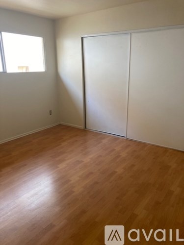 A room with wooden flooring and a white closet.