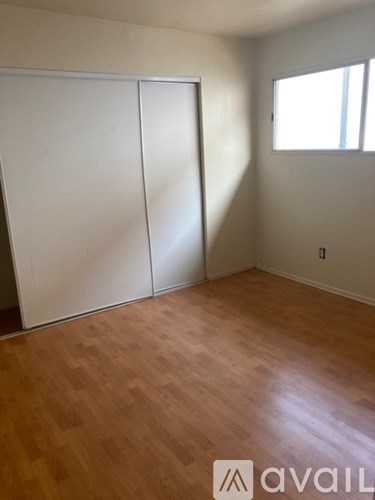 A room with wooden flooring and a white closet.