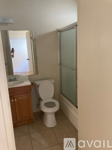 A bathroom with a toilet, sink, and shower.