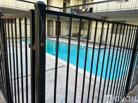 A black metal fence surrounds a blue pool.
