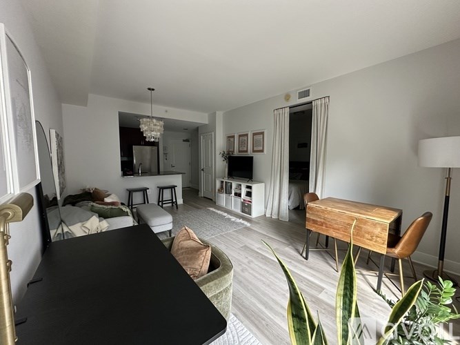 A living room with a couch, chairs, a table, and a television.