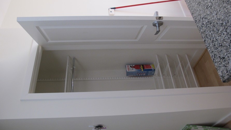 A white cabinet with a red line on the top and a white door.