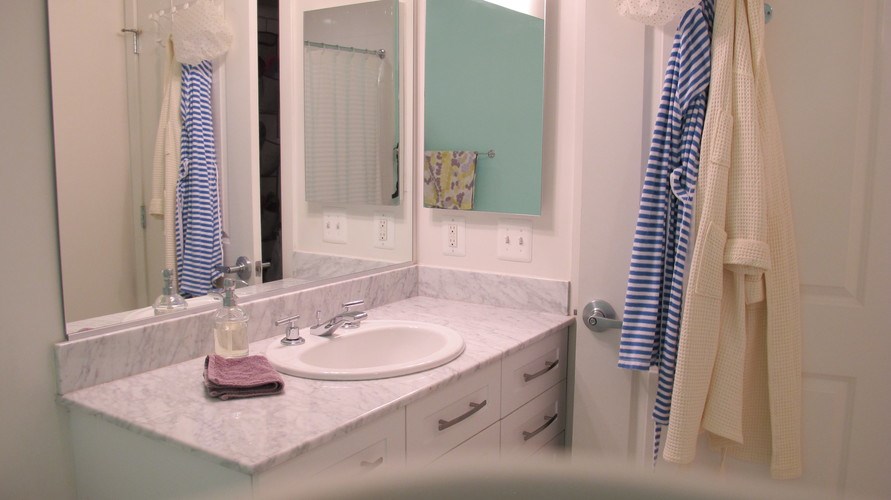 A bathroom with a sink, mirror, and towel.