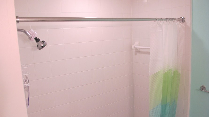 A shower with a glass door and a white shower head.