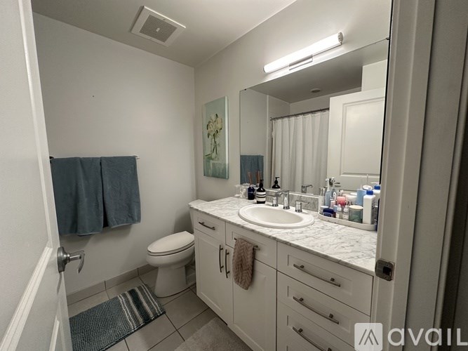 A room with a large window and a chandelier hanging from the ceiling.
