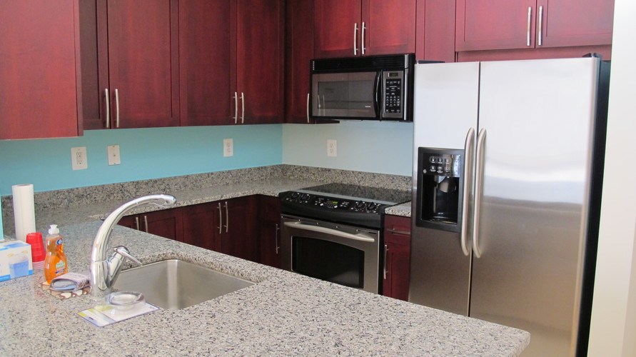 A kitchen with a sink, stove, and refrigerator.