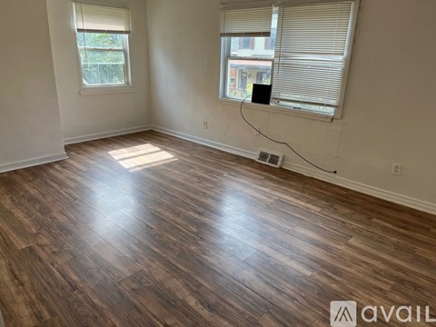 A room with wooden flooring and a window.
