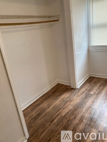 A room with wooden floors and two windows.