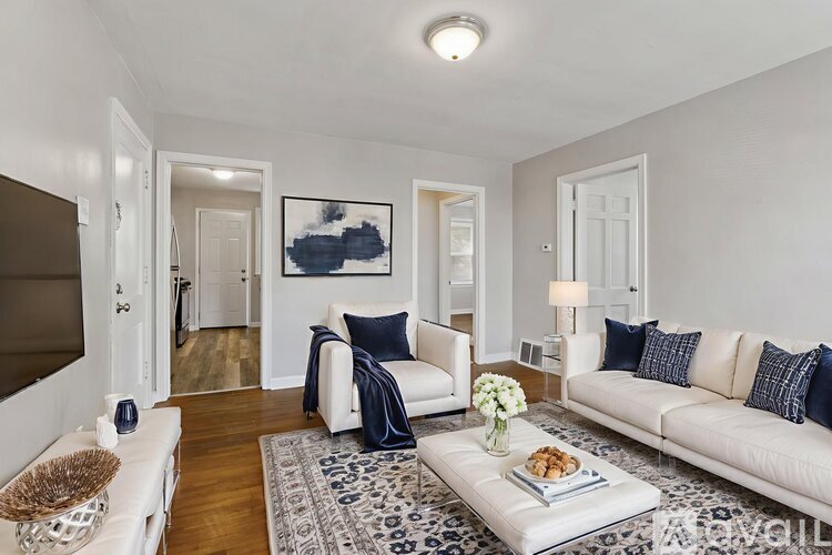 A living room with a grey couch, a brown armchair, a coffee table, and a television.