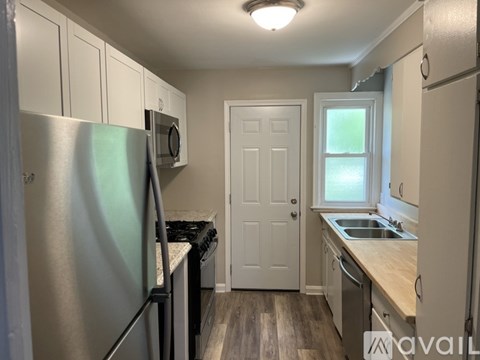 A kitchen with a refrigerator, stove, and sink.