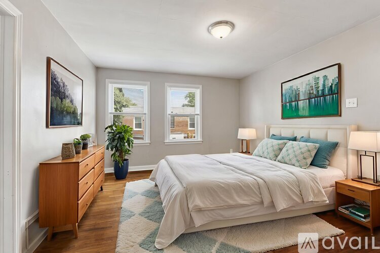 A bedroom with a bed, nightstand, and window.