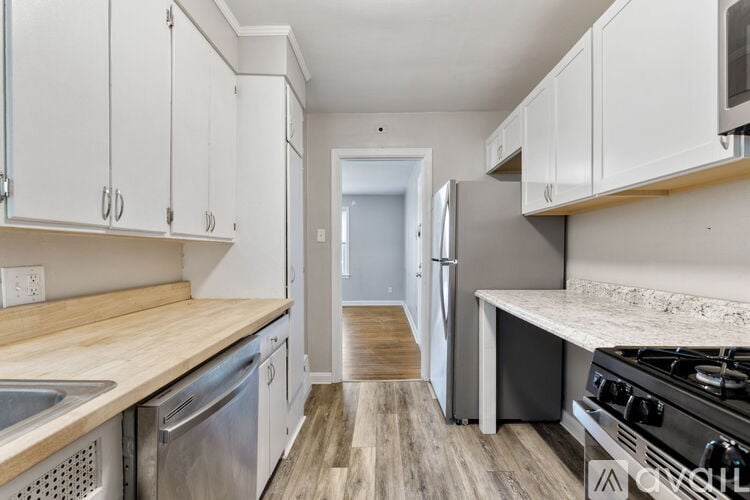 A kitchen with white cabinets and a wooden counter top.