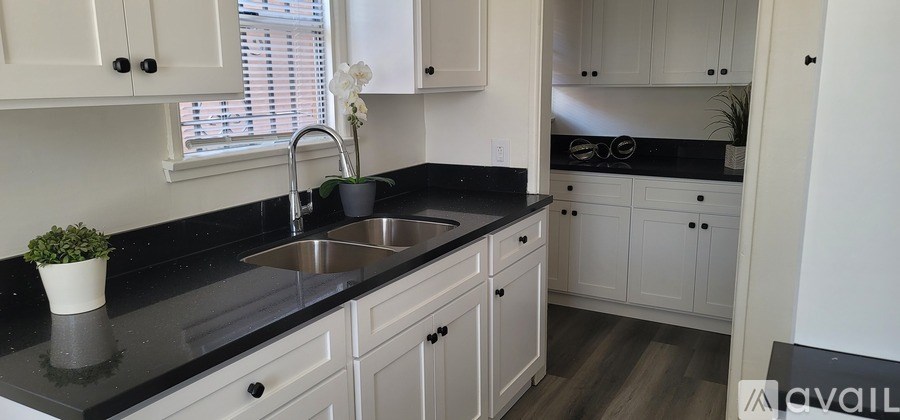 A kitchen with black countertops and white cabinets.