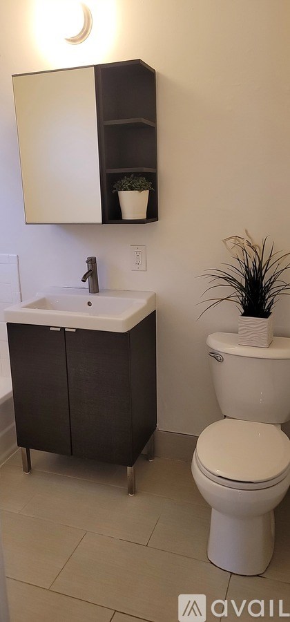 A bathroom with a toilet, sink, and medicine cabinet.
