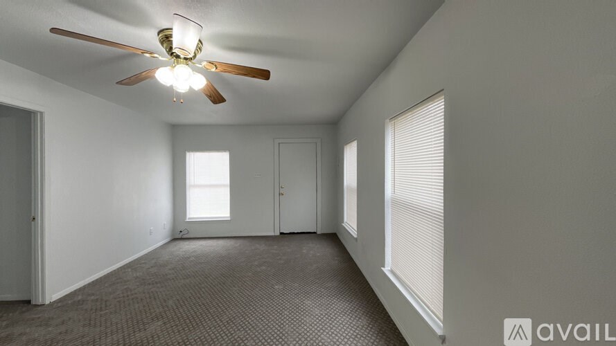 A room with a ceiling fan and carpeted floor.