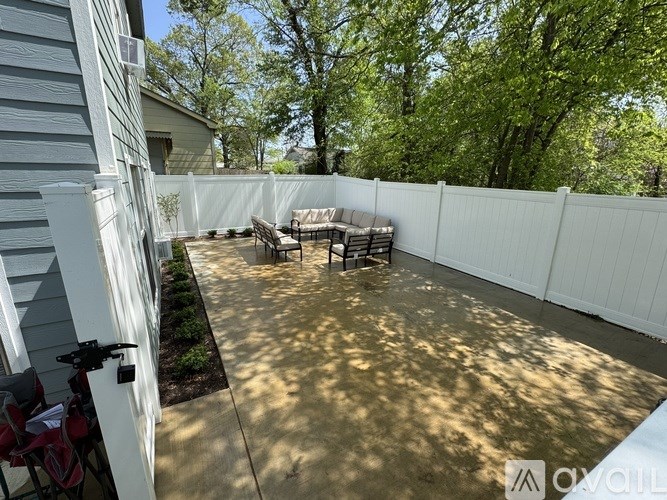 A patio with a white fence and a table and chairs.