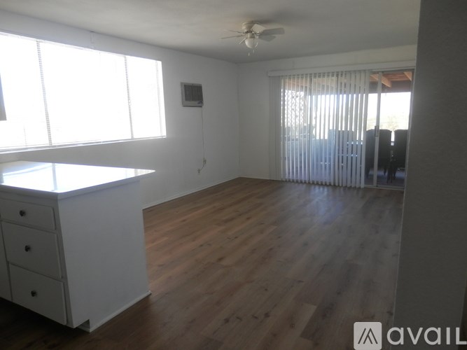 A room with wooden floors and a window with blinds.