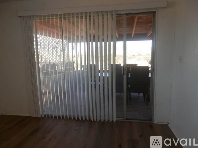 A room with a sliding door and a window covered with white blinds.