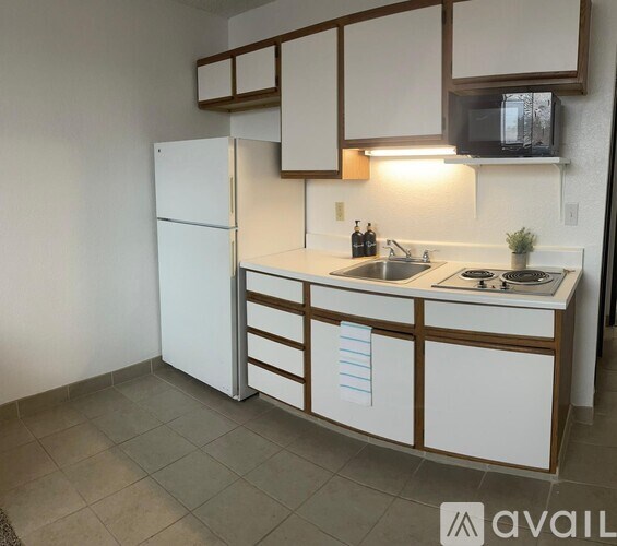 A kitchen with white cabinets and a white refrigerator.