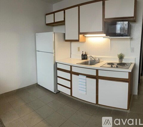 A kitchen with white cabinets and a white refrigerator.