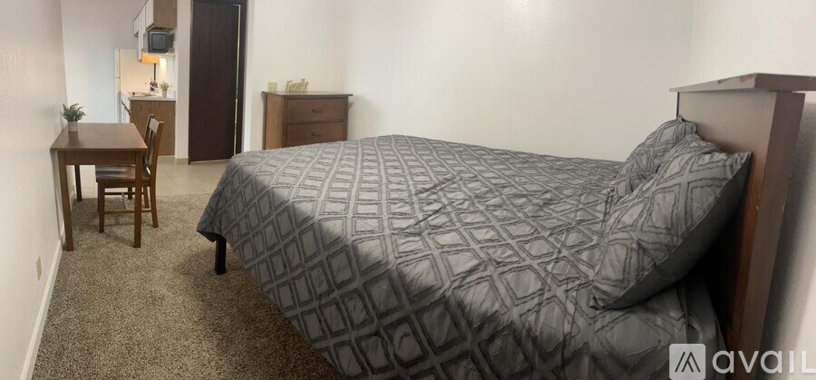 A bedroom with a bed, desk, and chair.