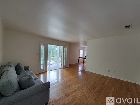A living room with a grey couch and wooden floors.