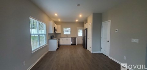 A spacious kitchen with white appliances and a dining area with a table and chairs.