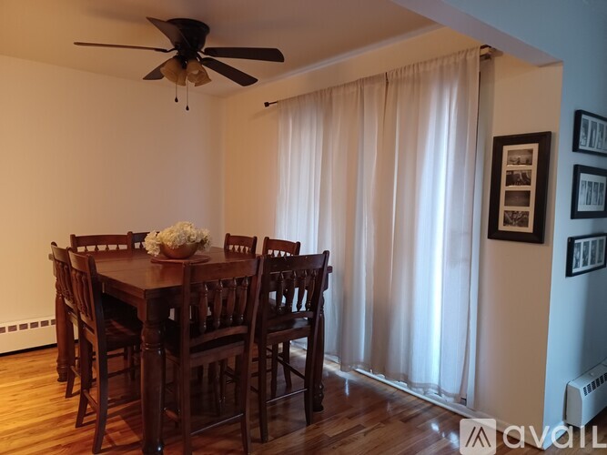 A dining room with a wooden table and chairs.