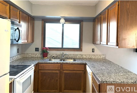 A kitchen with wooden cabinets and granite countertops.