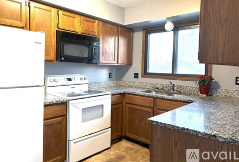 A kitchen with wooden cabinets and granite countertops.